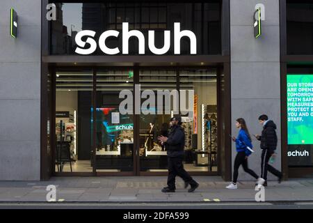 Die Käufer gingen vor den schuh-Laden in der Oxford Street London Stockfoto