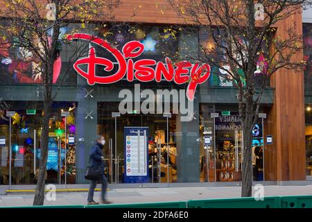 Ein Mann mit Gesichtsmaske ging an Disney-Laden in der Oxford Street London, England vorbei Stockfoto