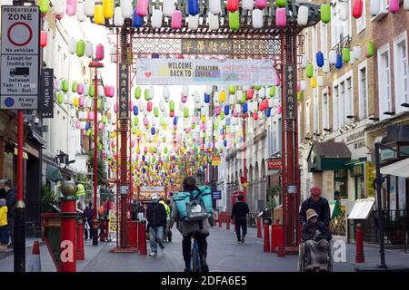 Deliveroo Fahrt nach London Chinatown in der Nähe von Leicester Square, mit älteren Paar schieben Rollstuhl für den Tag in Soho, London, England Stockfoto