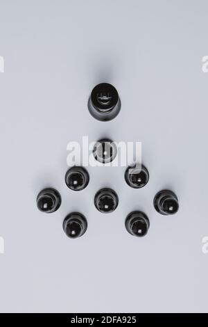 Overhead-Ansicht des schwarzen Königs gefolgt von Bauern auf weißem Hintergrund. Schachkonzept. Stockfoto