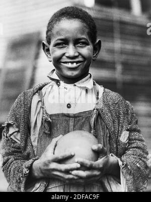 Young Boy with Grapefruit supplied by American Red Cross to dürre victims, Mound Bayou, Mississippi, USA, Lewis Wickes Hine, American National Red Cross Collection, 1930 Stockfoto