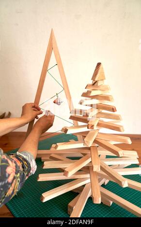 Bunte Weihnachtsbaum Arrangement mit Holz und Papier Minimal Silvester Saisonkonzept. Urlaub Grußkarte. Stockfoto