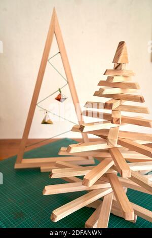Bunte Weihnachtsbaum Arrangement mit Holz und Papier Minimal Silvester Saisonkonzept. Urlaub Grußkarte. Stockfoto