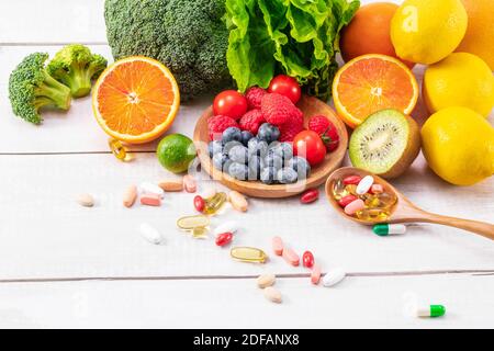 Ein schöner Schuss von frischem Obst und Gemüse mit verschiedenen Medizin auf einem Holzlöffel Stockfoto