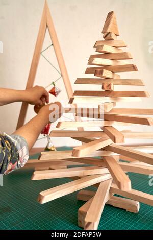 Bunte Weihnachtsbaum Arrangement mit Holz und Papier Minimal Silvester Saisonkonzept. Urlaub Grußkarte. Stockfoto