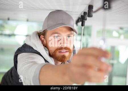 Elektriker verdrahten eine Deckenleuchte Stockfoto