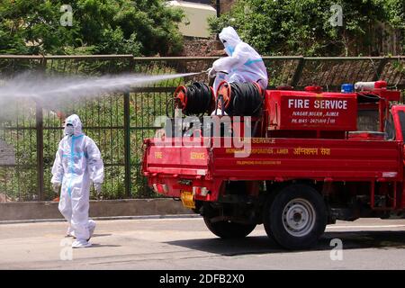 Indian Municipal Worker sprüht Desinfektionsmittel auf seine Kollegen, nachdem sie die Leiche eines COVID-19-Opfers in einem Krematorium in Ajmer, Rajasthan, Indien, am 19. Juni 2020 eingeäschert haben. Foto von Himanshu Sharma/ABACAPRESS.COM Stockfoto