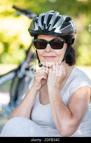 Ältere Frau, die einen Fahrradhelm aufsetzt Stockfoto