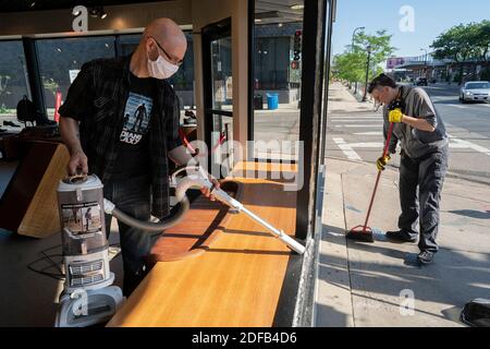 KEIN FILM, KEIN VIDEO, KEIN TV, KEIN DOKUMENTARFILM - Jeff Neppl, Left, und Megan Culverhouse, Mitarbeiter im John Fluevog Schuhgeschäft in Uptown, bereinigen zerbrochenes Glas von einem Fenster, das von einem Schussfeuer von einem frühen Morgenschießen am Sonntag, 21. Juni 2020 in Minneapolis, MN, USA getroffen wurde. Ein Teenager ist nach einem anderen Schießen in Minneapolis am Sonntag tot, dieses Mal in der Stadt Jordanien Nachbarschaft. Am Tatort sagten die Beamten, sie hätten ein 17-jähriges Opfer gefunden, das keinen Puls hatte und nicht atmete. Polizeisprecher John Elder sagt, dass die Beamten mit der Reanimation begannen und den Jungen in das Krankenhaus brachten, wo er starb. Pho Stockfoto