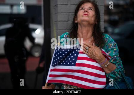 KEIN FILM, KEIN VIDEO, KEIN Fernsehen, KEIN DOKUMENTARFILM - Merrilyn Downs klingt die US-Flagge, als sie am Ort betet, wo am frühen Sonntagmorgen im 2900 Block der Hennepin Avenue South am Sonntag, dem 21. Juni 2020 in Minneapolis, MN, USA, eine Schießerei stattfand. Ein Teenager ist nach einem anderen Schießen in Minneapolis am Sonntag tot, dieses Mal in der Stadt Jordanien Nachbarschaft. Am Tatort sagten die Beamten, sie hätten ein 17-jähriges Opfer gefunden, das keinen Puls hatte und nicht atmete. Polizeisprecher John Elder sagt, dass die Beamten mit der Reanimation begannen und den Jungen in das Krankenhaus brachten, wo er starb. Foto von Jerry holt/Minneapoli Stockfoto