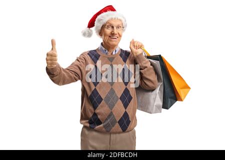 Senior mit einem weihnachtsmann Hut zeigt ein Handy Und hält Einkaufstaschen isoliert auf weißem Hintergrund Stockfoto