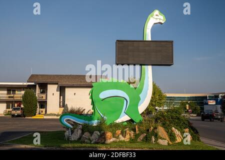 Vernal, Utah - 20. September 2020: Kitschiger grüner Dinosaurier am Straßenrand mit einem leeren Schild in der Innenstadt Stockfoto