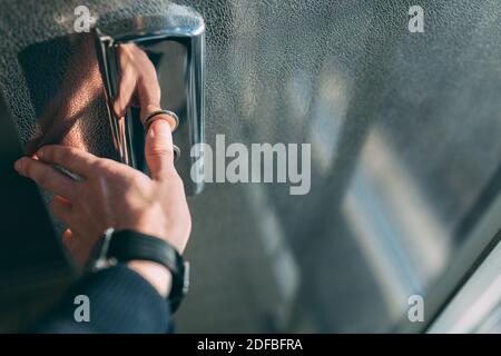 Der Daumen drückt die Elevator-Taste, eine Hand, die nach der Taste greift, das Mädchen wartet auf Elevator, Drucktaste Start, isoliert Stockfoto