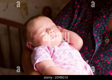 Schöne neugeborene Mädchen auf Frauen (Mutter oder Großmutter) Hände Stockfoto