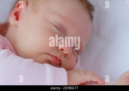 Neugeborenes Baby Mädchen trägt rosa Kostüm schlafen in einer Wiege Im Freien Stockfoto