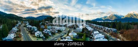 Luftpanoramic Ansicht von Wohnhäusern in einer touristischen Stadt. Farbenfroher Himmel Bei Sonnenaufgang. Aufgenommen in Squamish, nördlich von Vancouver, British Columbia, Kanada. Stockfoto