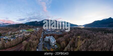 Luftpanoramic Ansicht von Wohnhäusern in einer touristischen Stadt. Farbenprächtiger Sonnenuntergang. Aufgenommen in Squamish, nördlich von Vancouver, British Columbia, Kanada. Stockfoto