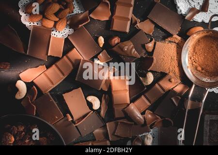 Schokolade Draufsicht Zutaten zum Backen mit Schokolade, Nüssen, Kakaopulver und Rosinen rustikalen Herstellung Dessert Hintergrund Stockfoto