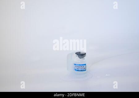 Langsam schmelzender Eiswürfel mit COVID-Impfstoff, eingefroren im Inneren Konzept von sehr niedrigen Lagertemperaturen für Corona-Virus-Impfstoff Glasfläschchen mit Vakuum Stockfoto