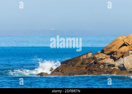 Meer Wellen auf einem Felsen brechen. Tiefblaue Meer Wellen Felsen schlagen, Schlagen, Felsen, Klippen. Mächtige Wellen des Meeres auf einem Felsen brechen, Spritzer über die Felsen. Starke ocea Stockfoto