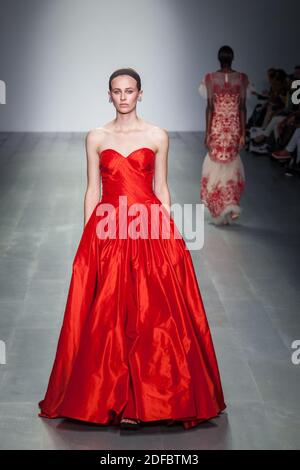 Model Walking down Runway in roten Abendkleid Modelle auf Laufsteg bei London Fashion Weekend Show, 2014 Stockfoto