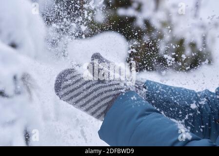 Frau in Fäustlingen klatscht Hände im Schnee, Winterzeit. Stockfoto