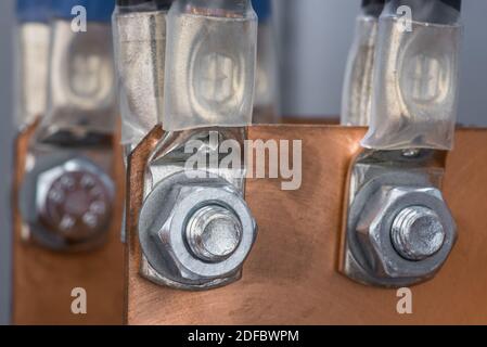 Verbindung des Elektrokabels mit Kupferschiene durch Schrauben Und Muttern in der Schalttafel der elektrischen Stromversorgung Stockfoto