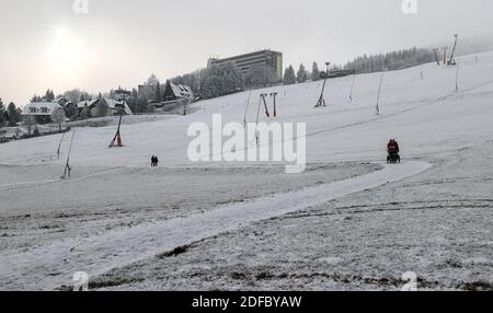 Oberwiesenthal, Deutschland. Dezember 2020. Passanten wandern über die Skipiste am Fichtelberg. In keinem anderen Bundesland breitet sich die Coronapandemie derzeit so schnell aus wie in Sachsen. Daher sind jetzt strengere Maßnahmen in Kraft, einschließlich Ausstiegsbeschränkungen. Alle Weihnachtsmärkte und Bergparaden wurden abgesagt. Quelle: Jan Woitas/dpa-Zentralbild/ZB/dpa/Alamy Live News Stockfoto