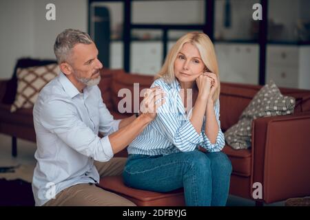 Mann und Frau sitzen auf dem Sofa und schauen nachdenklich Stockfoto