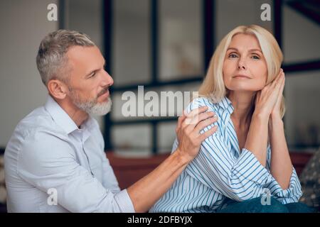 Mann und Frau sitzen auf dem Sofa und schauen nachdenklich Stockfoto