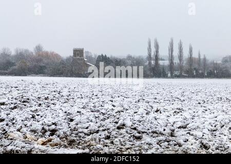 Dry Drayton Cambridgeshire, Großbritannien. Dezember 2020. Gepflügte Felder und der Kirchturm im Dorf Dry Drayton haben einen leichten Schneestaub im ersten Schnee dieses Winters. Eine Mischung aus Regen, Schnee und Schnee beeinflusste heute Morgen den Osten Englands und das Winterwetter wird sich in ganz Großbritannien fortsetzen. Kredit: Julian Eales/Alamy Live Nachrichten Stockfoto