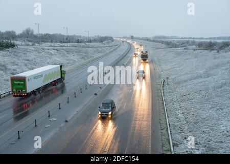 Hardwick Cambridgeshire, Großbritannien. Dezember 2020. Auf der A428 vor den Toren Cambridge gab es heute Morgen schlechte Fahrbedingungen für die Fahrer, da eine Mischung aus Regen, Schneeregen und dem ersten Schnee des Winters den Osten Englands beeinflusste. Das Winterwetter wird sich in ganz Großbritannien fortsetzen. Kredit: Julian Eales/Alamy Live Nachrichten Stockfoto