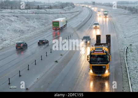 Hardwick Cambridgeshire, Großbritannien. Dezember 2020. Auf der A428 vor den Toren Cambridge gab es heute Morgen schlechte Fahrbedingungen für die Fahrer, da eine Mischung aus Regen, Schneeregen und dem ersten Schnee des Winters den Osten Englands beeinflusste. Das Winterwetter wird sich in ganz Großbritannien fortsetzen. Kredit: Julian Eales/Alamy Live Nachrichten Stockfoto