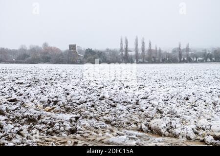 Dry Drayton Cambridgeshire, Großbritannien. Dezember 2020. Gepflügte Felder und der Kirchturm im Dorf Dry Drayton haben einen leichten Schneestaub im ersten Schnee dieses Winters. Eine Mischung aus Regen, Schnee und Schnee beeinflusste heute Morgen den Osten Englands und das Winterwetter wird sich in ganz Großbritannien fortsetzen. Kredit: Julian Eales/Alamy Live Nachrichten Stockfoto