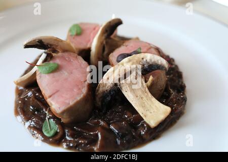 Teller Schweinefleisch mit Pilzen und Sauce Stockfoto