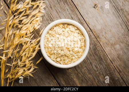 Schüssel mit ungekochten Hafer auf dem rustikalen Holzhintergrund. Selektiver Fokus. Geringe Schärfentiefe. Stockfoto