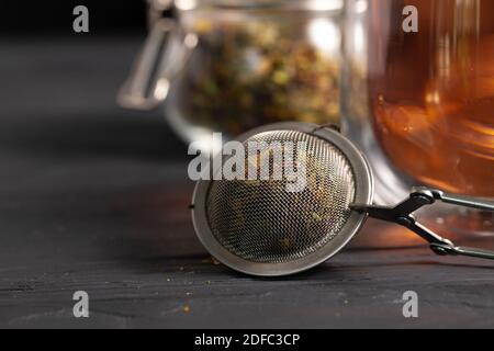 Teesieb aus Metall auf schwarzem Holztisch Stockfoto