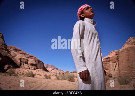 Jordanien, Porträt eines jungen Beduinen-Mannes in der Wadi Rum Wüste mit traditionellem weißen Kleid Stockfoto