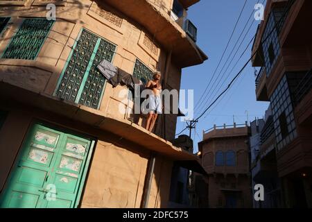 Indien, ein Mann betet (frühmorgens Puja Ritual) allein auf dem Balkon seines Hauses in Jodhpur Stockfoto