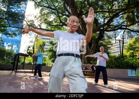 Hongkong, Gruppe von Männern, die morgens Tai Chi im Kowloon Park üben Stockfoto