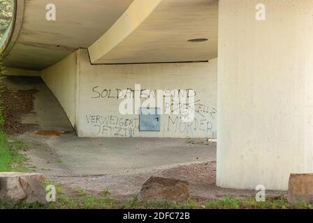 Brücke mit Graffito auf Soldaten in deutscher Sprache an einer Brücke Pier. Stockfoto