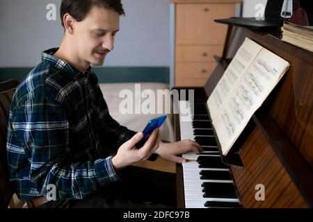 Lehrer spielt Klavier während seiner Online-Lektion Stockfoto