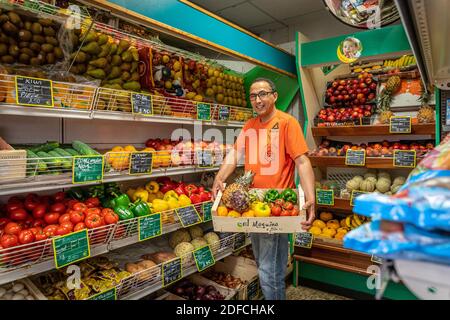 HASSAN IN SEINEM LEBENSMITTELGESCHÄFT UMGEBEN VON SEINEM OBST UND GEMÜSE, EURE, NORMANDIE, FRANKREICH, EUROPA Stockfoto