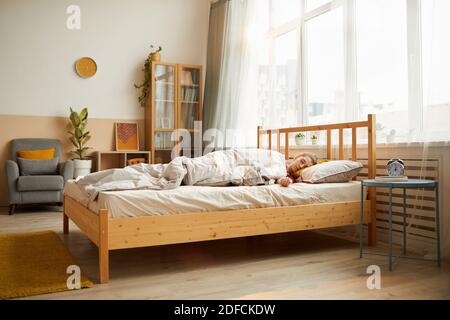 Junge Frau, die morgens im Bett schläft Modernes Schlafzimmer Stockfoto