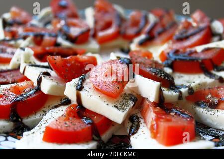 Caprese-Salat mit frisch geschnittenen Tomaten und Salzkäse auf dem Teller. Nahaufnahme. Stockfoto