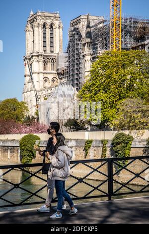 EINIGE CHINESISCHE TOURISTEN, DIE WÄHREND DER SPERRE VOR DER KATHEDRALE NOTRE DAME MASKIERT SIND, PONT DE L'ARCHEVECHE BRÜCKE, PARIS, 1. ARRONDISSEMENT, ILE-DE-FRANCE Stockfoto