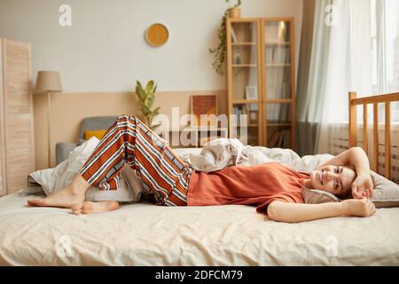 Porträt einer jungen Frau in häuslicher Kleidung entspannend auf sie Bett und genießen ihre Wochenenden zu Hause Stockfoto