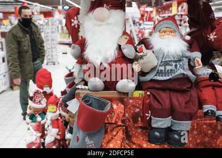 BRESLAU, POLEN - 27. NOVEMBER 2020. Weihnachtsdekoration im Supermarkt und Mann mit Gesichtsmaske im Hintergrund. Wegen Coronavirus Pandemie Cov Stockfoto