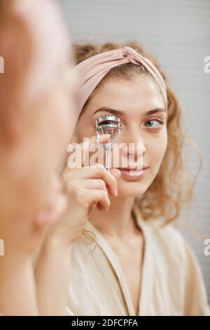 Junge schöne Frau kümmert sich um ihre Wimpern Blick auf Vor dem Auftragen von Make-up spiegeln Stockfoto
