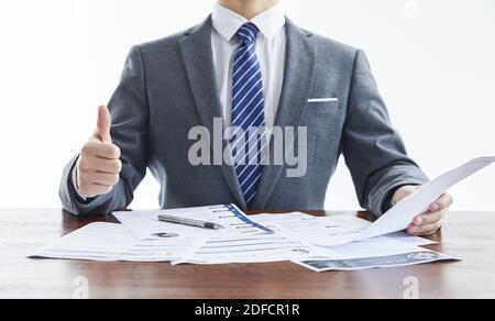 Der Geschäftsmann in elegantem Anzug bei einer Veranstaltung für Geschäftstreffen Sein Daumen hoch im Büro Stockfoto